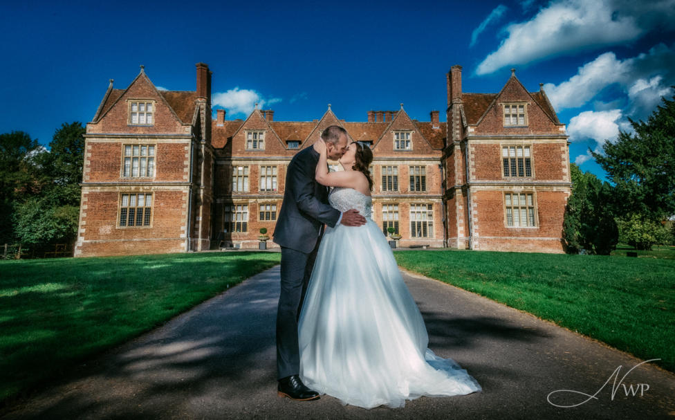 Romantic embrace for wedding couple in front of stunning Shaw House in Newbury