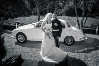 Elcot Park photographer with wedding couple and white Jaguar